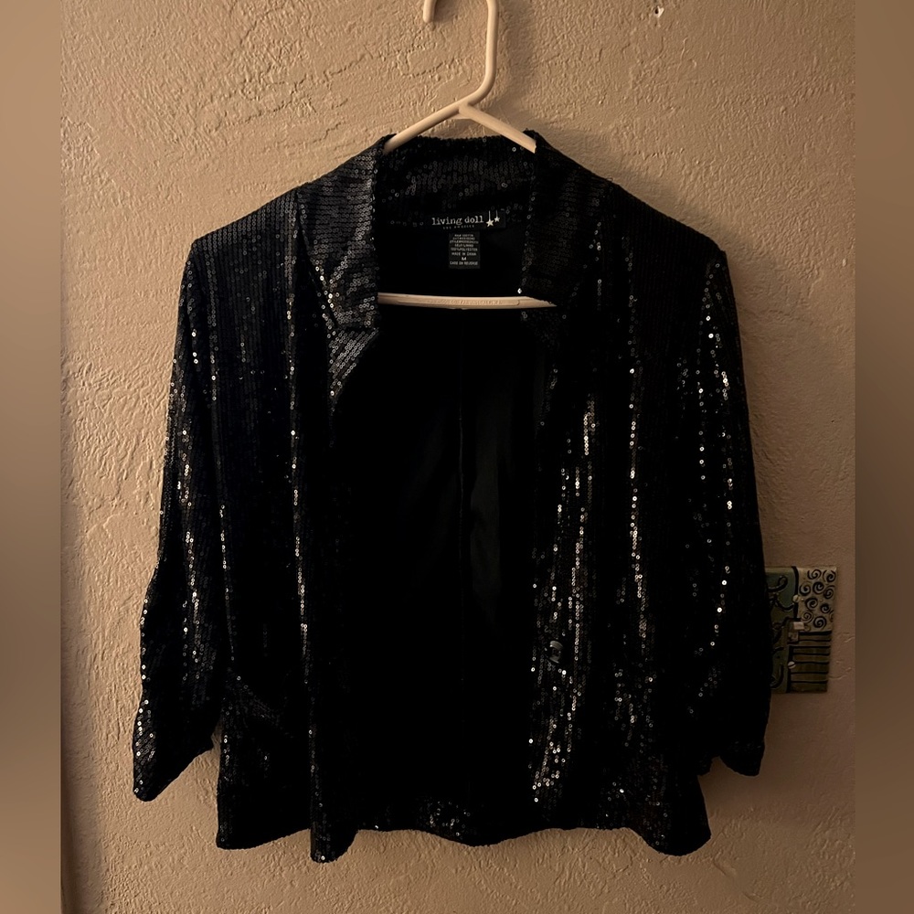 Black sequence jacket with pockets. Never been worn. Lined on the inside.